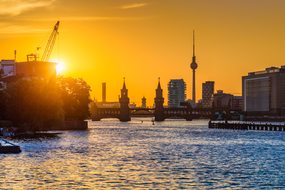 Beste Fotospots Berlin: Die Oberbaumbrücke bei Sonnenuntergang mit dem Berliner Fernsehturm in Hintergrund