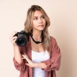 Junge Frau Kamera ueberlegt scaled 150x150 - Draußen fotografieren: 7 Tipps mit Buchempfehlung
